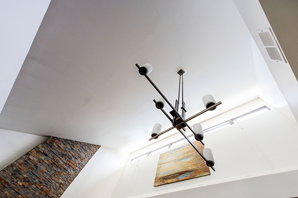 Looking up at light fixture, artwork and multi color brick wall