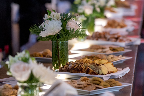 Platters of treats and flowers line a table