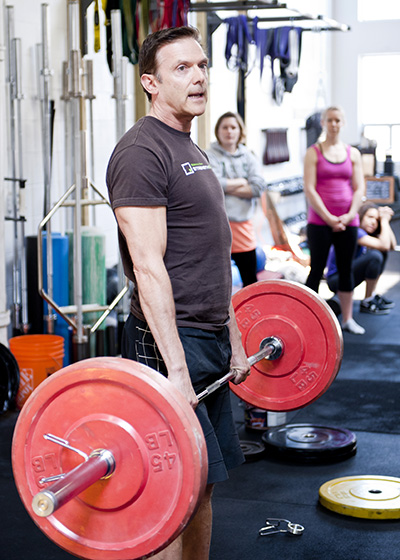 Greg Carver Founder and Certified Trainer lifts weights