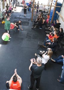 Participant powerlifts while group watches