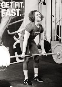 Female participant powerlifts and shows the emotion on her face