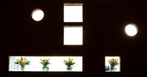 Closeup of window arch cutouts with flower arragements inside