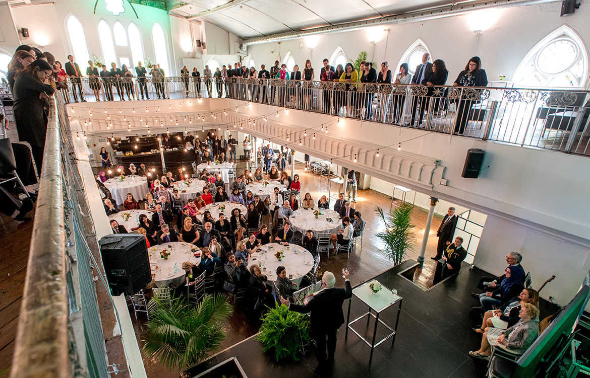 View of the event underway, balcony and main floor are full of guests