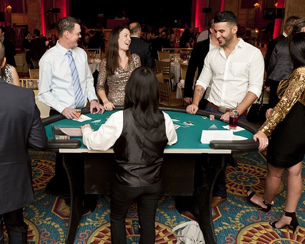 A dealer deals cards to players at the black jack table