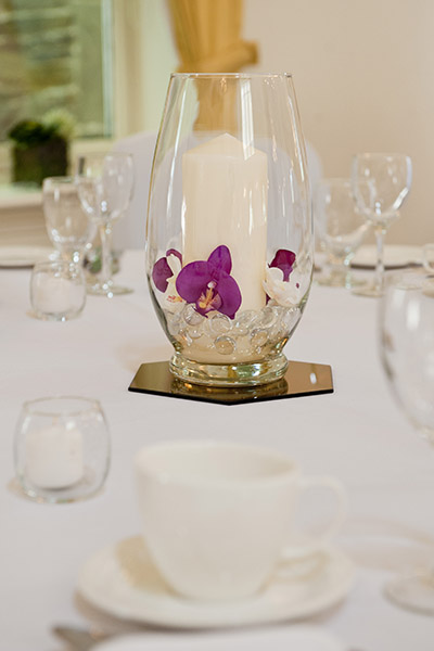 Wedding decor, orchids in a vase decorate the middle of a table