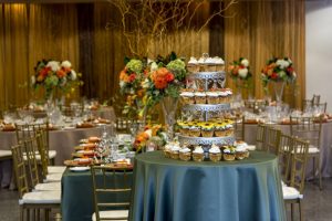 View of table settings, cake display and gold curtain decor