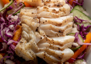 Flaked cod on bed of onion, cred cabbage, cucumber and orange pepper