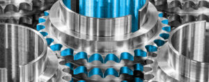 Black and White Photograph of cogs partially coloured blue.